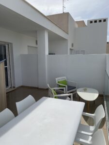 Balkon met eettafel en zitje.